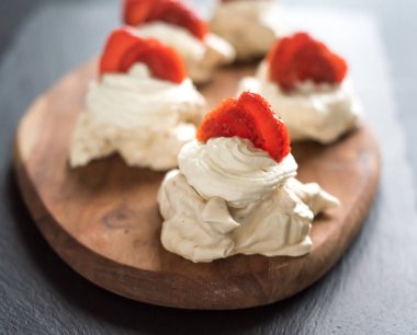 Ahşap bir arka planda gurme tatlı pavlova çileği