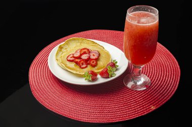 Beyaz tabakta şerbetli çilek ve krep.