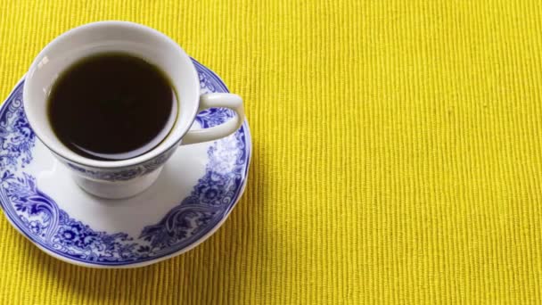 Фарфоровая Чашка Кофе Поверх Желтого Плацемата — стоковое видео