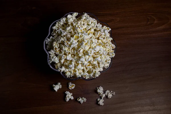 Popcorn bowl on the wooden table. Top view.