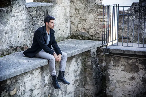 Man sitting on stone edge — Stock Photo, Image