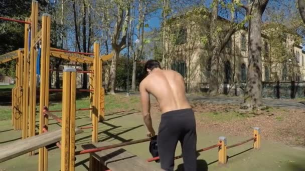 Νεαρός άνδρας άσκηση στο υπαίθριο γυμναστήριο — Αρχείο Βίντεο