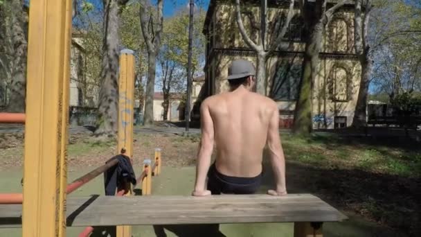 若い男が屋外ジムで運動 — ストック動画