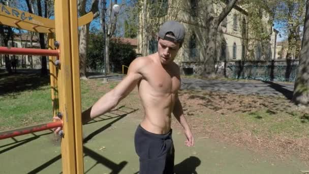 Hombre joven haciendo ejercicio en el gimnasio al aire libre — Vídeos de Stock