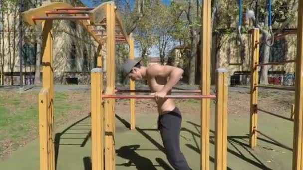 Junger Mann trainiert in Fitnessstudio im Freien — Stockvideo
