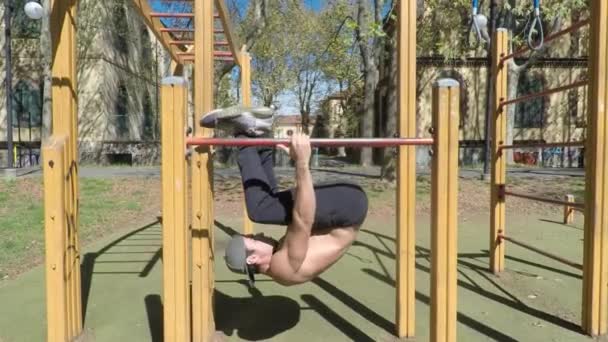 Hombre joven haciendo ejercicio en el gimnasio al aire libre — Vídeo de stock