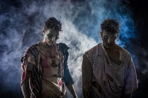 Dos zombies hombres pie sobre fondo ahumado negro —  Fotos de Stock