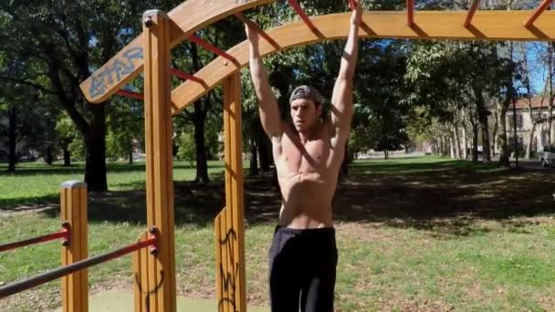 Hombre joven haciendo ejercicio en el gimnasio al aire libre — Vídeos de Stock