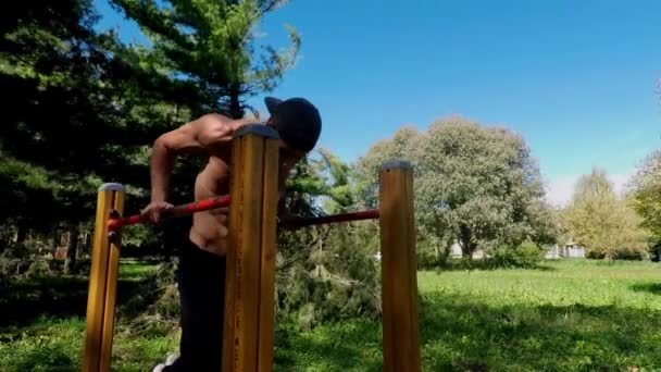 Hombre joven haciendo ejercicio en el gimnasio al aire libre — Vídeos de Stock