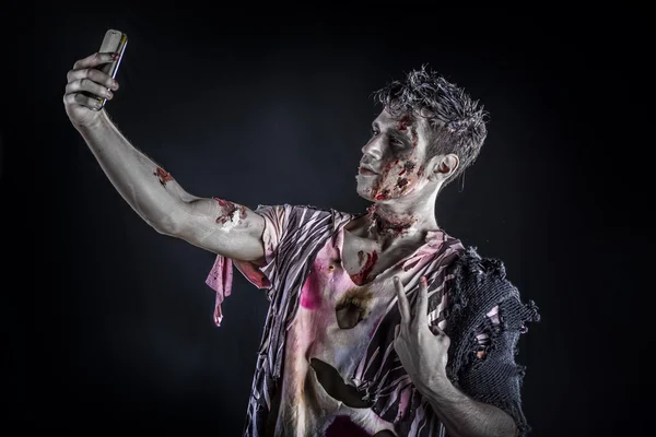Mâle zombie à l’aide de téléphone portable pour prendre selfie, permanent — Photo