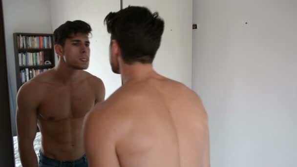 Молодой красавчик проверяет свои зубы в зеркале — стоковое видео