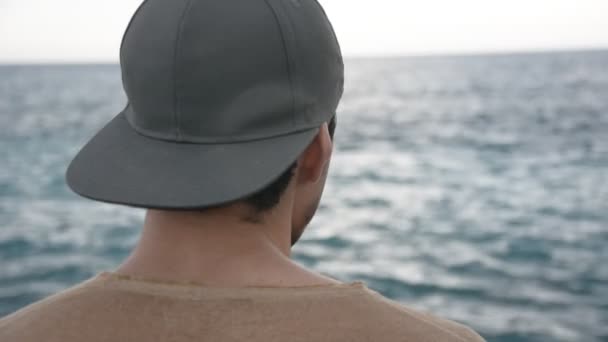 Joven escribiendo y pensando frente al mar — Vídeo de stock