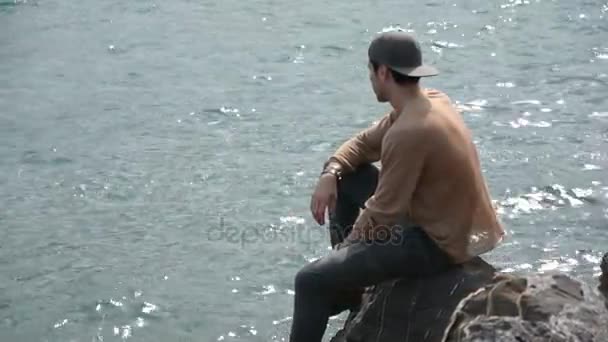 Young Man Sitting and Thinking in front of Sea — Stock Video