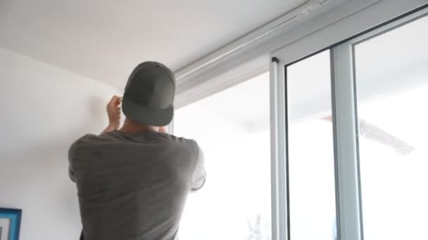 Homem muscular cuidadosamente cortinas penduradas — Vídeo de Stock