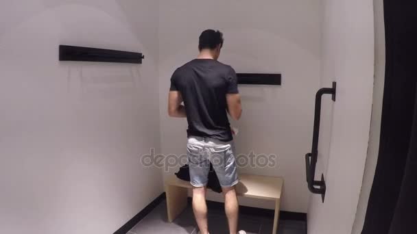 Hombre joven probándose la ropa en la tienda de ropa — Vídeos de Stock