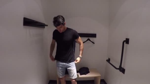 Giovane uomo che prova vestiti nel negozio di abbigliamento — Video Stock