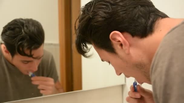Knappe man poetsen tanden in de badkamer — Stockvideo
