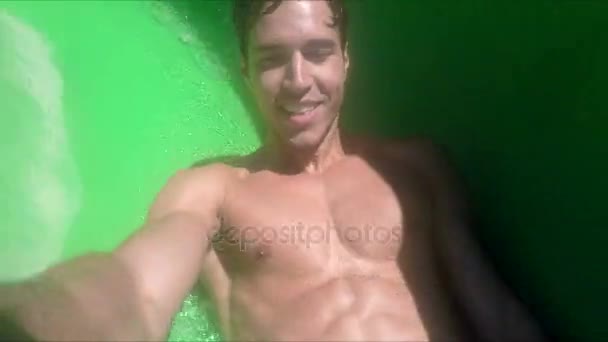 Handsome emotional man riding water slide — Stock Video