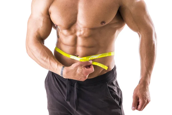 Muskelkräftiger Bodybuilder misst Bauch mit Maßband — Stockfoto