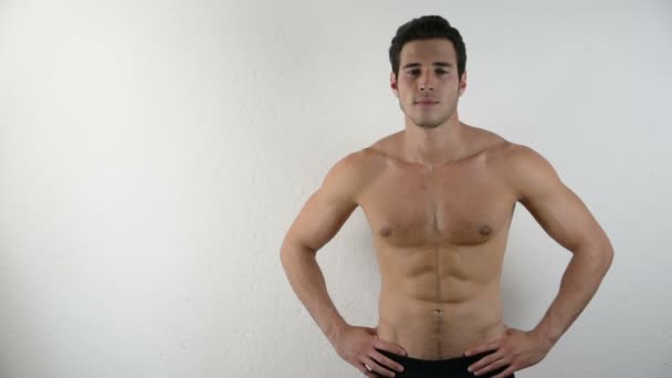 Knappe shirtloze atletische jonge man op wit — Stockvideo