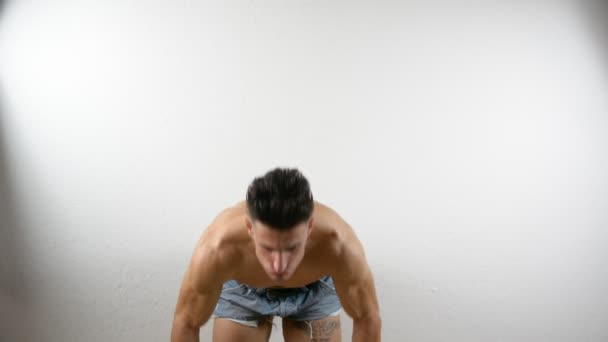 Musculoso joven sin camisa haciendo ejercicio con pesas — Vídeo de stock