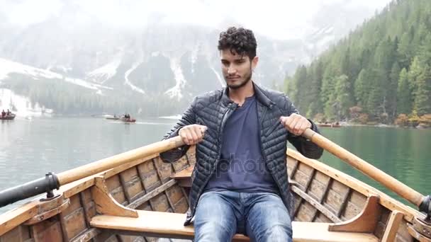 山の湖でボートでボートの若い男 — ストック動画
