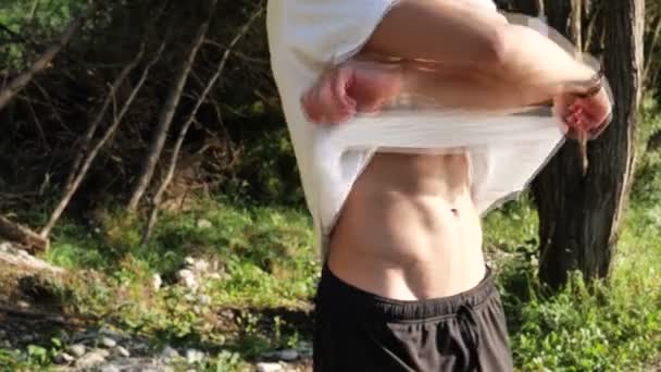 Attraktiver muskulöser junger Mann zieht sich aus — Stockvideo