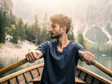 Yakışıklı adam kayıkta kürek