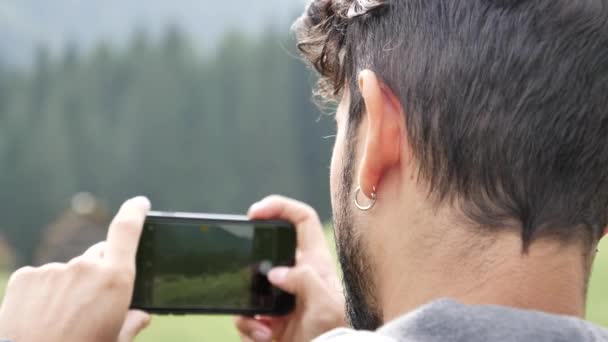 Hombre filmando vídeo de vacas en la montaña — Vídeo de stock