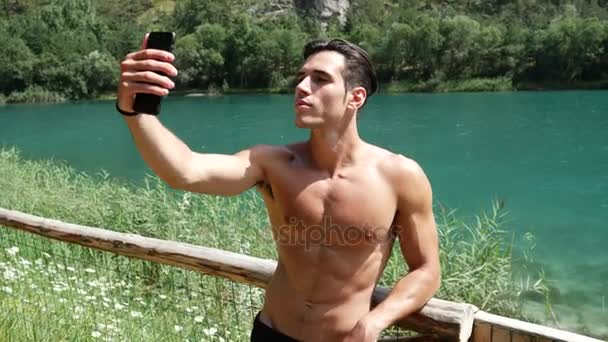 Mann macht Selfie am See — Stockvideo