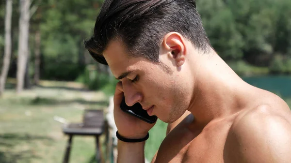 Man making phone call at lake — Stock Photo, Image