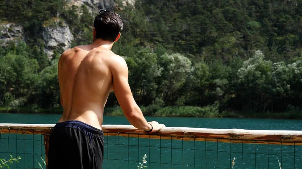 Jeune homme merdique regardant le lac — Photo