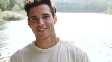 Yakışıklı genç bir göl kıyısında veya nehir