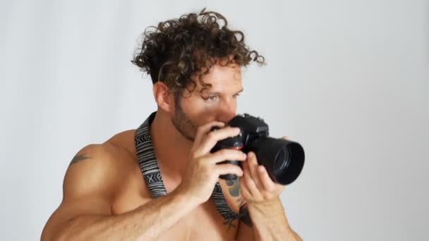Hemdloser junger Mann mit professioneller Fotokamera — Stockvideo