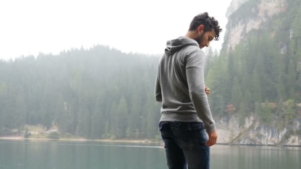 Hombre joven relajándose en el lago de montaña — Vídeo de stock