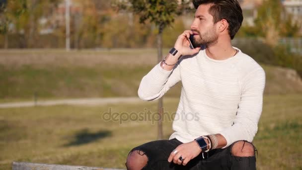 Jeune homme faisant un appel téléphonique en plein air en ville — Video