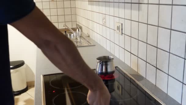 Молодой человек готовит завтрак для себя — стоковое видео