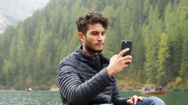 Homem tirando foto no lago com smartphone — Vídeo de Stock