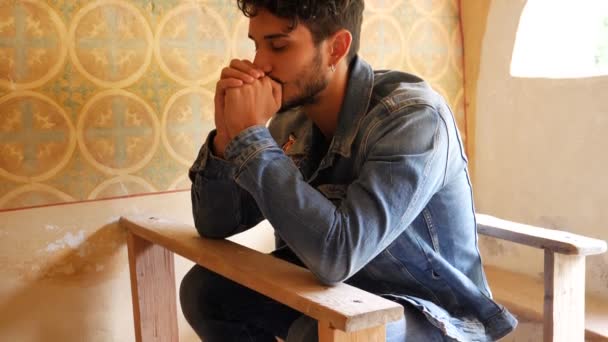 Young man praying in small chapel — Stock Video