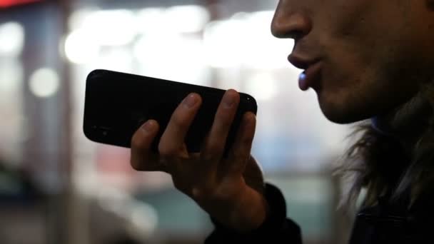 Молодой человек отправляет голосовое сообщение с мобильным телефоном — стоковое видео