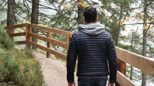 Jovem caminhadas em exuberante paisagem de montanha verde — Vídeo de Stock