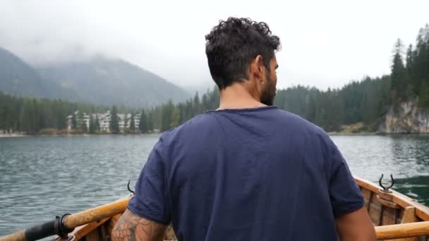 Jovem remando em barco no lago da montanha — Vídeo de Stock