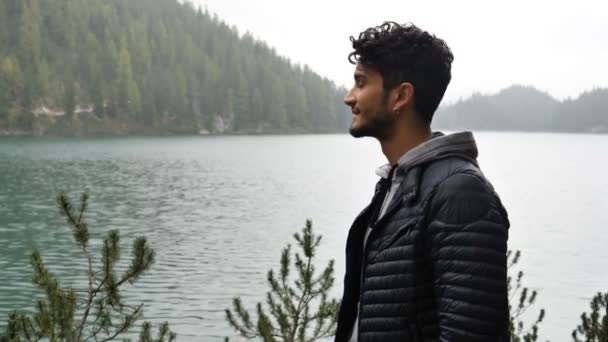 Jovem relaxante no lago da montanha — Vídeo de Stock