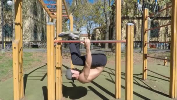 Hombre joven haciendo ejercicio en el gimnasio al aire libre — Vídeo de stock