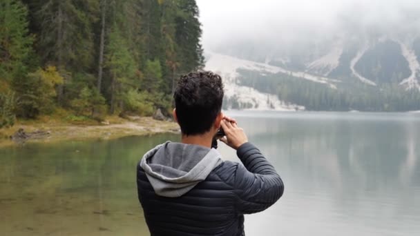 Hombre tomando fotos en el lago con cámara de acción — Vídeo de stock