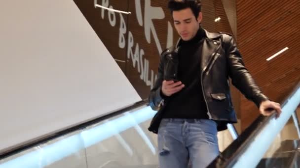 Giovane uomo sulla scala mobile nel centro commerciale — Video Stock