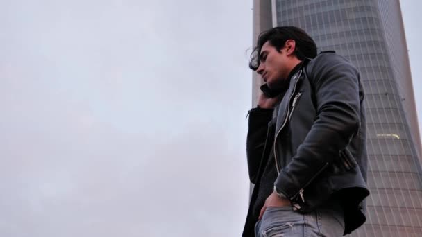 Hombre joven en hablar en el teléfono celular al aire libre en la ciudad — Vídeo de stock