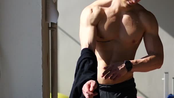 Μικρά ταιριάζει άνθρωπος απογειώνεται πουκάμισο στο γυμνός μυϊκή κορμού — Αρχείο Βίντεο