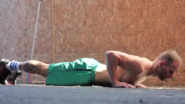 Handsome young man in gym doing push-ups on the floor — Stock Video