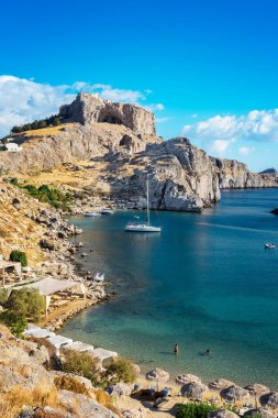 Beautiful St. Paul´s bay with boats, Lindos acropolis in backgr clipart